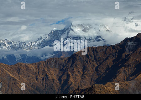 Picco di montagna di Chaukamba fra nubi marrone con montagna cresta in primo piano, l'Himalaya, Uttarakhand, India. Vista dal Monte Chandrashila Foto Stock