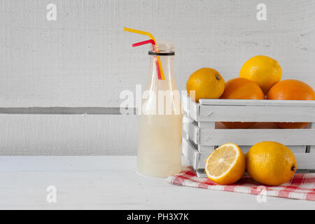 Composta di agrumi in bottiglia con arance e limoni su bianco Foto Stock