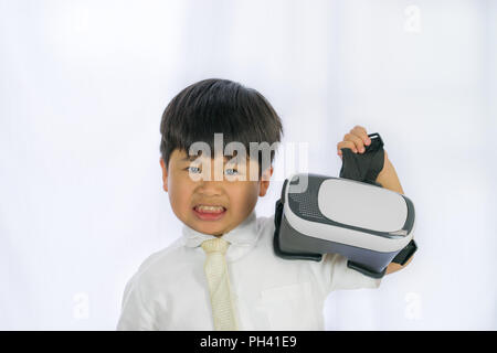 Little Boy holding 3D occhiali su sfondo bianco, immagine ritratto Asian carino Ragazzo che sorride, Foto Stock