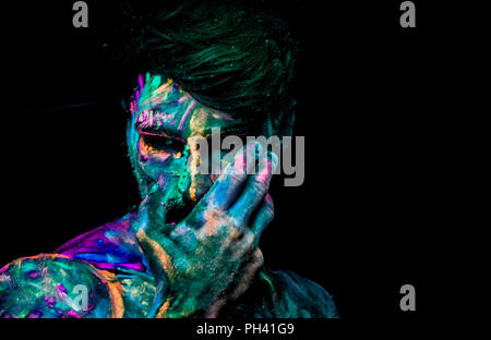 Giovane uomo dipinta in vernice fluorescente Foto stock - Alamy