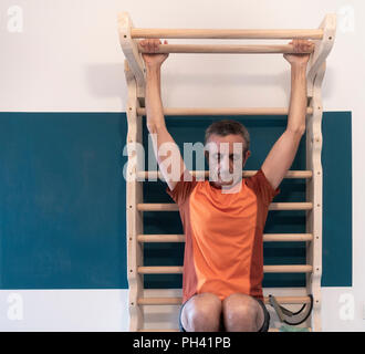 61 anno vecchio esercizio a casa sulla parete in casa bar nel piccolo appartamento. Foto Stock