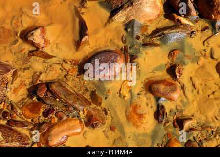 Il bizzarro fondo del fiume Odiel, con le pietre e i fanghi tinto di toni incredibili. Nella provincia di Huelva, vicino le miniere di Riotinto, Spagna Foto Stock