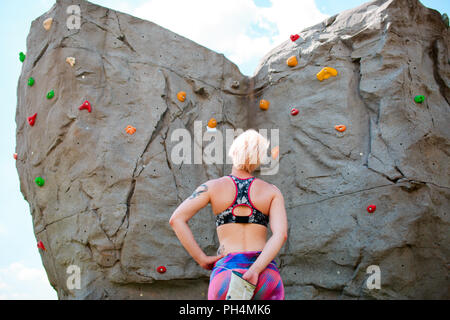 Foto dal retro di sportive scalatore con la sacca di sapone contro il rock boulder Foto Stock