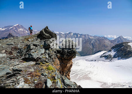 Femmina solitario escursionista sopra Saas Fee, a Mittelallalin comprensorio sciistico estivo, Saastal, Svizzera Foto Stock