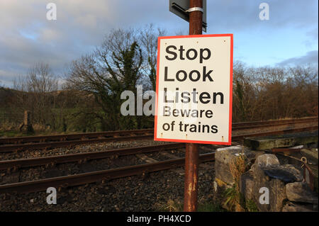 Stop look Ascolta il cartello con la scritta Unmanned Railway Level Crossing, Grange-over-Sands, Cumbria, Inghilterra, Regno Unito Foto Stock