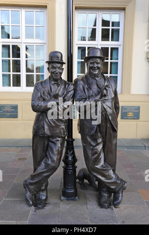 Laurel & Hardy statua di bronzo Ulverston, Cumbria, luogo di nascita di Stan Laurel nel 1890. Il duo comico sta appoggiandosi su un lampione e sorridendo Foto Stock