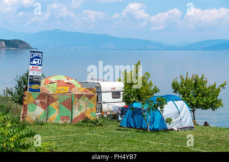 Un campeggio con il dipinto era comunista bunker sulle rive del lago di Ohrid a Pogradeci, sud est Albania. Foto Stock