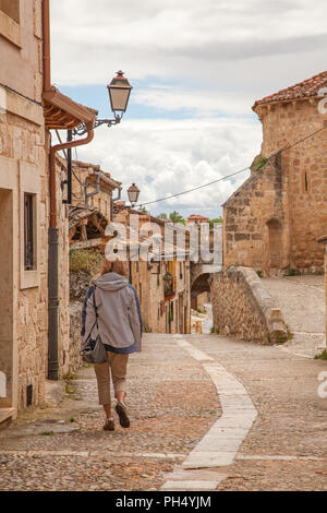 Donna vacanziere passeggiando lungo le strade di ciottoli nel medievale cittadina spagnola di Maderuela in Castiglia y Leon Spagna Foto Stock