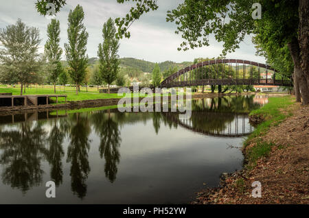 Ponte pedonale e la sua riflessione sul fiume Sertã, Sertã, Portogallo. Foto Stock