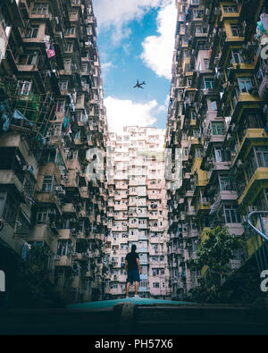 Uomo che guarda un aeroplano a Quarry Bay, Hong Kong. Foto Stock