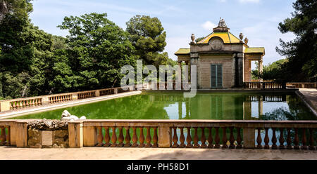 Padiglione neoclassico di Carlos IV e un quadrato laghetto con pesci nel labirinto di Horta Park. Il padiglione è stato costruito nel 1794 da Domenico Bagutti. Foto Stock