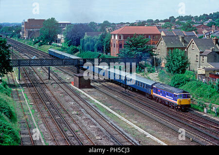 Una classe 33 locomotiva diesel numero 33114 'Ashford 150' con 4TC i numeri di unità 410 e 417 la formazione di un vuoto di lavoro stock avvicinando Wimbledon il 10 luglio 1992. Foto Stock