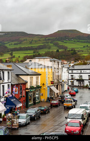 Crickhowell High Street che mostra il Bear Hotel con il Brecon Beacons dietro, POWYS, GALLES Foto Stock