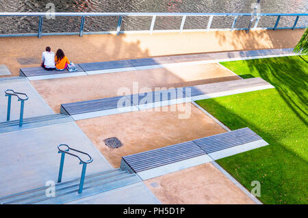 Un giovane seduto guardando il fiume Lea su alcuni passi - Londra 2012 Olympic Park Foto Stock