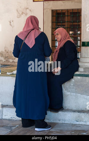 Bosnia: le donne musulmane in attesa per la preghiera presso la Koski Mehmed Pasha moschea, la seconda più grande moschea di Mostar esempio di Architettura Ottomanna Foto Stock