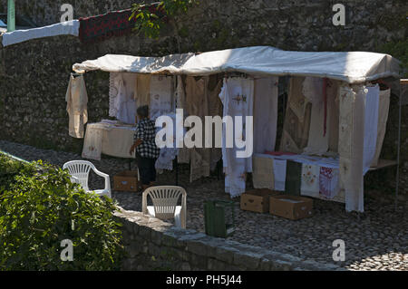Bosnia: bosniaco vecchia donna vendita finemente tessuti ricamati e pizzi, creata secondo l antica tradizione balcanica nei vicoli della città di Mostar Foto Stock