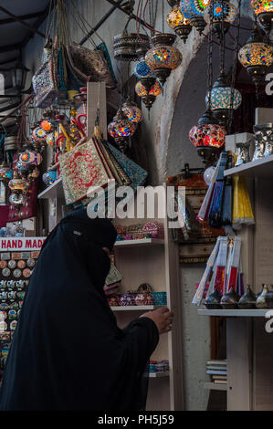 Bosnia: una donna musulmana velata va shopping in uno dei numerosi negozi del Vecchio Bazar Kujundziluk, il quartiere musulmano della città vecchia di Mostar Foto Stock