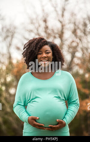 Felice americano africano donna in stato di gravidanza Foto Stock