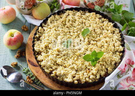 Mele crumble, croccante in una teglia sul tavolo di legno. Foto Stock