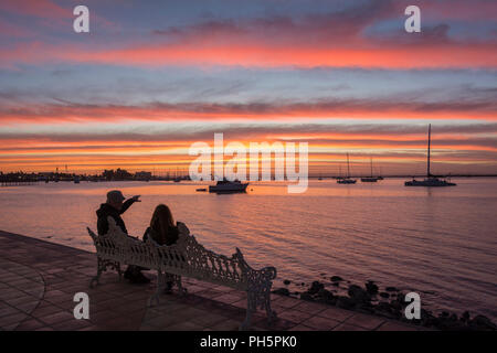 Paio di godersi il tramonto da una panca sul Malecon a La Paz, Baja California Sur, Messico. Foto Stock