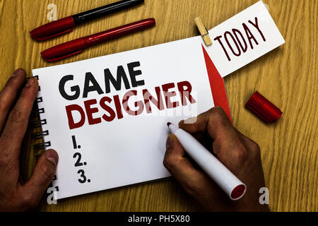 La grafia la scrittura di testo Game Designer. Concetto significato i diruttori Pixel ai programmatori di scripting di console grafica 3D Uomo con notebook marcatore vestire Foto Stock