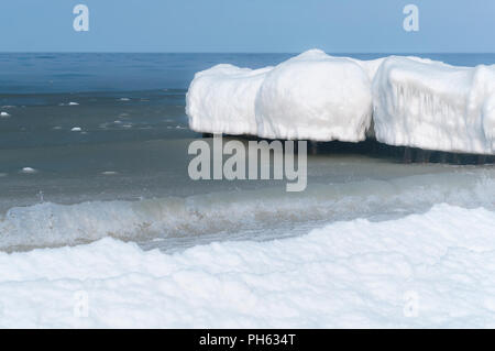 Le onde del mare nella neve ghiacciata granite, ghiaccio sulle scogliere in mare, mare costa in inverno Foto Stock