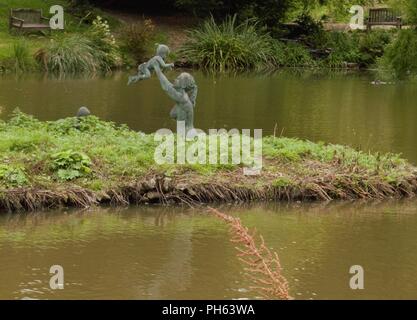 Bella madre e figlio a riprodurre la statua Foto Stock