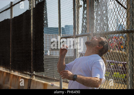 Un forte calore all'aperto un uomo prende una doccia nel parco Foto Stock