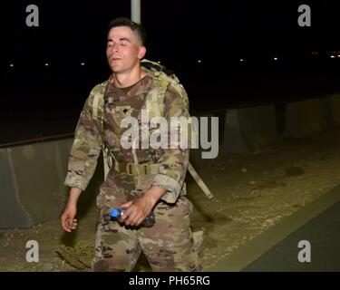 Stati Uniti Army Spc. Marcus Dabash, un alfa della batteria di missili Patriot manutentore, 5-52 Difesa aerea artiglieria, prende un respiro e mentalmente si concentra durante un 12-Mile ruck Marzo, Giugno 19, 2018 at Al Udeid Air Base, in Qatar. Il 12-Mile ruck marzo è stato uno dei tre fisicamente impegnative sfide progettato per spingere i concorrenti ai loro limiti durante un trimestrale guerriero migliore concorrenza. Foto Stock