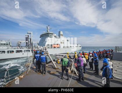 Mare (26 giugno 2018) i marinai a bordo guidato-missile destroyer USS Farragut (DDG 99) heave linea per collegare una sonda di rifornimento di carburante come la nave conduce a una ricostituzione in mare con la British Royal ausiliario della flotta di navi cisterna di rifornimento RFA Tidespring (A136). Farragut è attualmente implementato come parte di Harry Truman Carrier Strike gruppo. Con USS Harry Truman (CVN 75) come ammiraglia, distribuito strike gruppo unità includono staffs, di navi e di aeromobili di Carrier Strike gruppo Otto (CSG 8), Destroyer Squadron due otto (DESRON 28) e Carrier aria Wing uno (CVW-1); come pure Sachsen-classe Friga tedesco Foto Stock