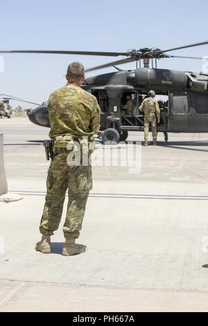 Esercito Australiano Col. Michael dire, comandante del Task Group Taji, orologi come Stati Uniti Esercito il Mag. Gen. Walter Piatt, vice comandante della transizione della Combined Joint Task Force - Funzionamento inerenti risolvere, così come il suo team si allontana dal Camp Taji dopo un breve a nord di Baghdad il comando delle operazioni presso il Camp Taji, Iraq, 18 giugno 2018. Attivato da successi accelerata contro ISIS nel 2017, le forze di coalizione il supporto ai nostri partner è in fase di evoluzione come possiamo assistere i nostri partner nel fornire sicurezza che consente gli sforzi di stabilizzazione. Foto Stock