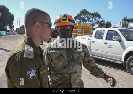 TEL AVIV, Israele - militari israeliani Il Mag. Igal Raskin, sinistra, spiega l'esercizio finale del Fronte Unito VII per Indiana esercito nazionale Guard Brig. Gen. Wayne L. nero, comandante della 81st comando di truppa, durante la sua visita a osservare il 30 guardie del XIX CBRN risposta avanzato pacchetto di forza in corrispondenza di Zikim Base di Formazione Giugno 20, 2018. Xix CERFP cross-treni con forze israeliane e combinate unisce, costruire e rafforzare le relazioni tra le nazioni e le forze. Foto Stock