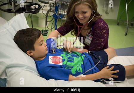 COLORADO SPRINGS, Colo. - Mentre Tom Echelmeyer ottiene il suo per via endovenosa per infusione di immunoglobulina, Kristen Rodgers, Ospedale per i bambini del provider Colorado esegue un checkup presso i bambini Colorado urgente e ambulatoriali cure speciali a Briargate in Colorado Springs, Colorado, 15 giugno 2018. Tom la Mamma Sofia Echelmeyer, lo porta in ospedale una volta al mese per la sua infusione e esami del sangue. Foto Stock