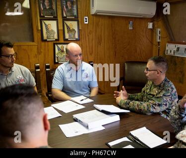 Stati Uniti Marine Col. Michael H. Oppenheim, il comandante della Special Purpose Marine Air-Ground Task Force - Comando Sud, parla di Chris Williams e Matt Lonnquest, entrambi rappresentanti con gli Stati Uniti Agenzia per lo Sviluppo Internazionale dell'Ufficio Stranieri di assistenza di emergenza, all'SPMAGTF-SC sede su Soto Cano Air Base, Honduras, 27 giugno 2018. Durante la visita, leader SPMAGTF fornito l'OFDA rappresentanti con un illustre visitatore breve su misura per OFDA interessi e preoccupazioni, e ha fornito una breve panoramica del SPMAGTF prossimo coinvolgimento in una catastrofe umanitaria Foto Stock