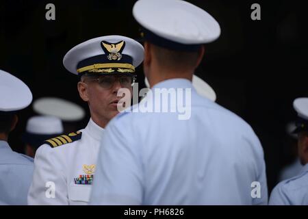 Il cap. William Timmons, Comandante della Guardia Costiera Settore Columbia River, ispeziona un membro dell'equipaggio del settore Columbia River, durante la modifica del comando cerimonia di premiazione si terrà presso il settore di base in Warrenton, Ore., 28 giugno 2018. Timmons registrato più di 5.600 ore di volo nel formato HH-60 e MH-60 Jayhawk elicotteri durante i suoi 27 anni di servizio di guardacoste. Foto Stock