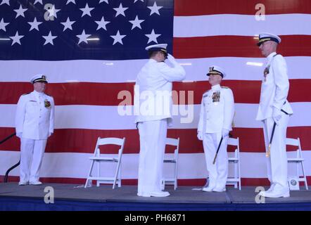 Il cap. Jeremy Smith saluta Adm posteriore. David Throop, Comandante della Guardia Costiera XIII quartiere, come egli prende il comando del settore Columbia River, durante una cerimonia tenutasi presso il settore di base in Warrenton, Ore., 28 giugno 2018. Smith alleviato Capt. William Timmons come comandante del settore Columbia River. Foto Stock