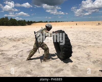 Pvt. Di Naod Alemayehu, nativo di New York City che rappresenta la cinquantaduesima Ordnance Gruppo (EOD), ribalta un 120-pound pneumatico durante lo stress shoot esercizio come parte del xx chimica, biologica, radiologica, nucleare e gli esplosivi (CBRNE) Comando 2018 miglior guerriero di concorrenza a base comuneGuire-Dix Mc-Lakehurst, N.J. Questo concorso annuale il test le capacità fisiche e mentali di soldati concorrenti al fine di selezionare il sottufficiale e soldato dell'anno che competono agli Stati Uniti Il comando delle forze a Fort Bragg, N.C. Foto Stock