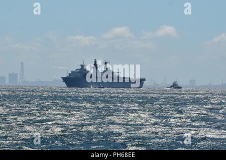 YOKOSUKA, Giappone - La British Royal Navy Amphibious Assault nave HMS Albion (L 14) arriva a U.S. Le attività della flotta (FLEACT) Yokosuka per una porta programmata visita. FLEACT Yokosuka fornisce, mantiene e gestisce servizi di base e servizi a sostegno del settimo della flotta di inoltro distribuito le forze navali, 71 comandi di tenant, e 27.000 militari e civili. Foto Stock