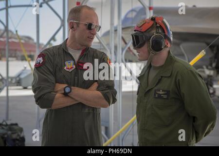 Stati Uniti Airman Il Mag. Caleb 'Skeet' Guthman, un pilota, attaccato alla Hill Air Force Base in Utah, discute gli esercizi futuri con gli Stati Uniti Marine Corps Cpl. Samuel Beddoes, un aviation ordnance tecnico con Marine Fighter Attack Squadron (VMFA) 122, Marine Corps Air Station (ICM) Yuma, su ICM Yuma, Ariz., 26 giugno 2018. L'esercizio testato per la prima volta la interoperabilità di caricamento di sistemi di armi tra i servizi F-35's. Gli Stati Uniti Air Force opera con la F-35un fulmine II, mentre gli Stati Uniti Marine Corps opera con la F-35B Lightning II. Foto Stock