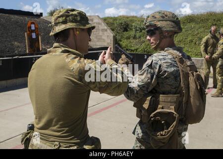 MARINE CORPS BASE HAWAII (29 giugno 2018) Esercito Australiano Cpl. Peter Swan, un fante con il secondo battaglione, Royal Australian Regiment, armi fornisce istruzioni per la manipolazione degli Stati Uniti ad un Marine durante un live fire evento di formazione da parte di RIM del Pacifico (RIMPAC) esercitare all'Ulupa'u cratere gamma Training Facility in Marine Corps base Hawaii Giugno 29, 2018. RIMPAC fornisce un elevato valore di formazione per attività organizzata, altamente in grado Marine Air-Ground Task Force e migliora la crisi critica la capacità di risposta degli Stati Uniti Marines nel Pacifico. Venticinque nazioni, 46 navi, cinque sommergibili, Foto Stock