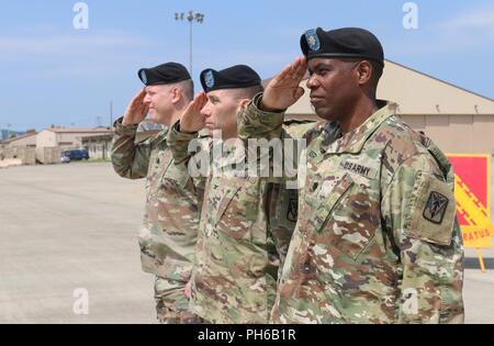 Col. Richard Wright, 35th Air Defense Artillery comandante di brigata, Lt. Col. Marc Pelini, comandante uscente del 6° Battaglione, 52nd difesa aerea reggimento di artiglieria, e il tenente Col. Matthew Walker, 6-52 ADA Bn. Comandante in arrivo, salutate come inno nazionale è svolto durante un cambio del comando cerimonia, Giugno 15, 2018 a Suwon Air Base, Repubblica di Corea. Pelini rinunciato a comando per Walker, dopo due anni di comando contrassegnate da alte conquiste nella prontezza. ( Foto Stock