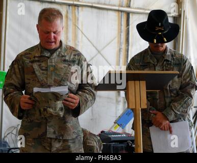 Località segreta - Il Mag. John Mozingo (sinistra), cappellano per la 449th combattere la Brigata Aerea, offre l invocazione all'inizio del trasferimento di autorità cerimonia di Foxtrot Company, 227th reggimento aviazione Giugno 24, 2018. La cerimonia indica una unità di entrata assumendo il comando dall'unità di rinunciare a. La società assume la missione di abilitazione, degli Stati Uniti e della Coalizione nazioni partner per sconfiggere e distruggere ISIS a sostegno di funzionamento inerenti risolvere utilizzando MQ-1C GRIGIO Eagle sistemi aerei senza pilota. Foto Stock