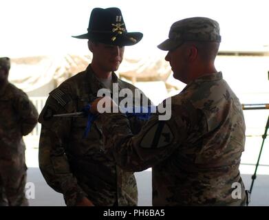 Località segreta - Capt. James Burns, comandante di Foxtrot Company, 227th reggimento di aviazione, 449th combattere la Brigata Aerea e 1 Sgt. Brandon Casper distendere i colori aziendali durante un trasferimento di autorità cerimonia Giugno 24, 2018. La cerimonia indica l'assunzione di comando mediante l'unità di entrata la cui missione è di consentire U.S., coalizione e nazioni partner per sconfiggere e distruggere ISIS a sostegno di funzionamento inerenti risolvere utilizzando MQ-1C GRIGIO Eagle sistemi aerei senza pilota. Foto Stock