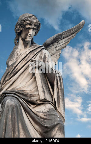 Angelo in marmo con tavolo contro blu cielo molto nuvoloso Foto Stock