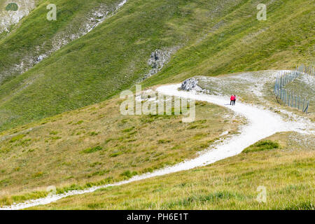 Coppia umana sul sentiero di montagna colpo lungo il trekking a piedi estate Foto Stock