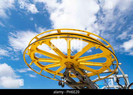 Chiudere fino a basso angolo di visione del giallo ski lift macchinari macchine di grandi dimensioni ruota contro il cielo blu Foto Stock