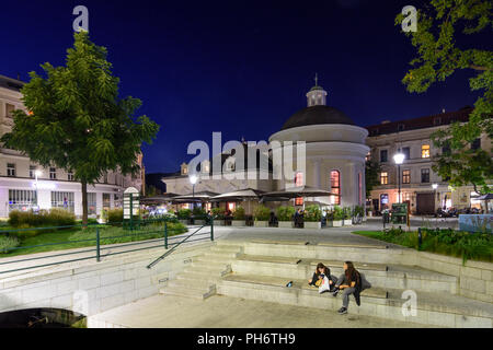 Baden: square Josefsplatz, ristorante in ex spa Josefsbad, giovani seduta, stream Mühlbach, Wienerwald, Vienna Woods, Niederösterreich, Lowe Foto Stock