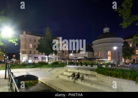 Baden: square Josefsplatz, ristorante in ex spa Josefsbad, giovani seduta, stream Mühlbach, Wienerwald, Vienna Woods, Niederösterreich, Lowe Foto Stock