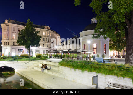 Baden: square Josefsplatz, ristorante in ex spa Josefsbad, giovani seduta, stream Mühlbach, Wienerwald, Vienna Woods, Niederösterreich, Lowe Foto Stock