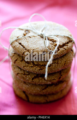 Gingersnaps sulla biancheria rosa avvolto con dello spago Foto Stock